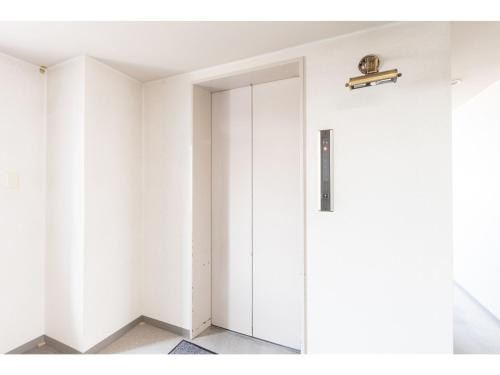 Habitación con puerta blanca y estante en la pared en HOTEL DRAKE - Vacation STAY 61998v en Odawara