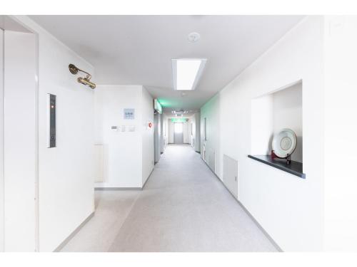 a hallway with white walls and a long corridor at HOTEL DRAKE - Vacation STAY 61996v in Odawara