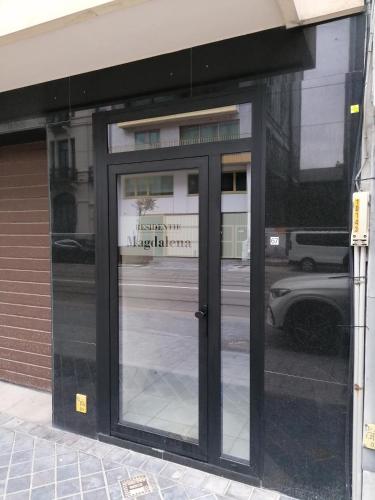 a glass door of a building with a sign on it at WeLoveOostende - Newly renovated large apartment 150m from the beach - Including bed sheets and final clea-ning in Ostend