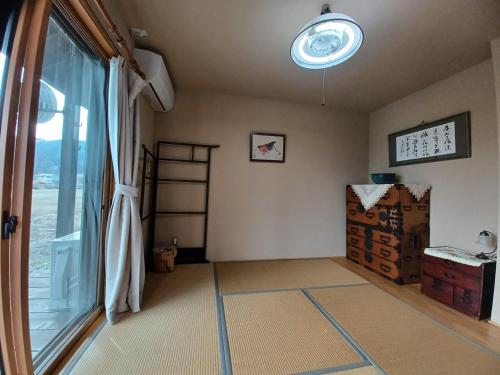 Kazeoka Sakuma - Vacation STAY 63930v في Iiyama: غرفة بها نافذة كبيرة وغرفة بها مقبلات