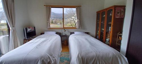 Kazeoka Sakuma - Vacation STAY 63930v في Iiyama: سريرين في غرفة مع نافذة