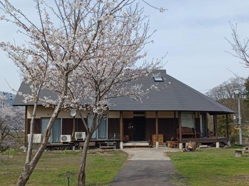 ein Haus mit einem Baum davor in der Unterkunft Kazeoka Sakuma - Vacation STAY 63930v in Iiyama
