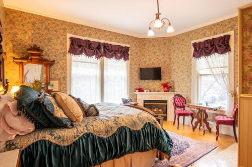 um quarto com uma cama, uma secretária e uma lareira em Aurora Staples Inn em Stillwater