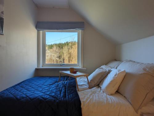 a room with a bed and a table and a window at Countryside experience in a Cozy Loft Near Bergen in Frekhaug