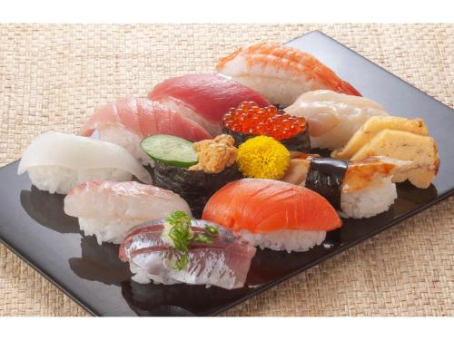 talerz wypełniony sushi i warzywami na stole w obiekcie HOTEL DRAKE - Vacation STAY 62003v w mieście Odawara