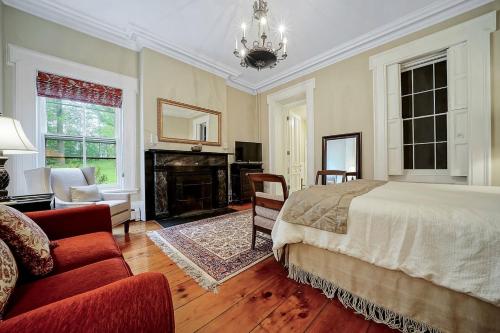 um quarto com uma cama e uma lareira em Cromwell Manor Inn em Cornwall-on-Hudson