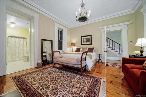 a bedroom with a bed and a chair and a couch at Cromwell Manor Inn in Cornwall-on-Hudson