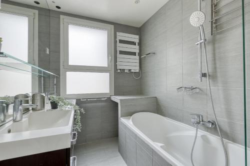 a bathroom with a bath tub and a sink at Superb & Luminous T4 apartment in Montmartre in Paris