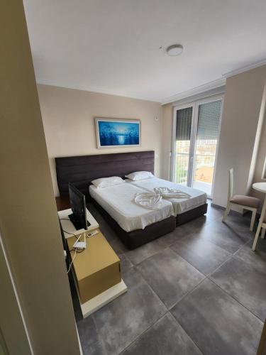1 dormitorio con 1 cama y escritorio con ordenador en Studio holidays en Shëngjin