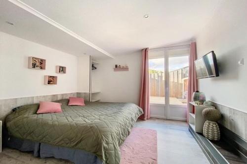 Un dormitorio con una cama con almohadas rosas y una ventana en Maison avec terrasse à quelques minutes de la place Morny, en Deauville