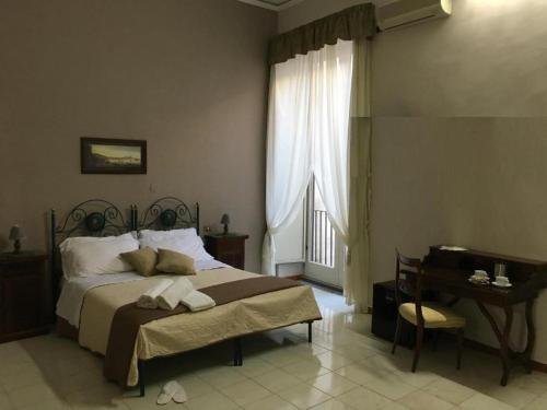 a bedroom with a bed and a table and a desk at Soggiorno Paradiso in Naples