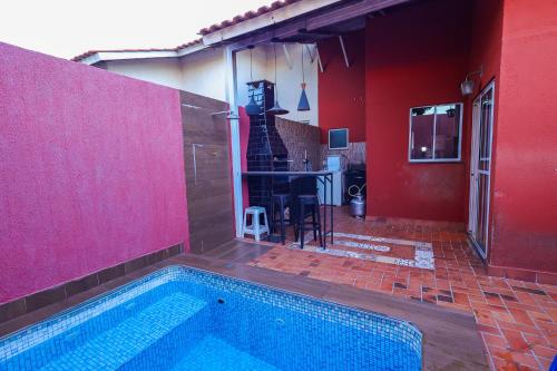 uma casa com uma piscina e uma parede vermelha em Casa aconchegante em Goiânia em Goiânia