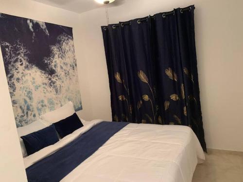 a bedroom with a bed with a black curtain at Sunrise Stays-Airport and zona colonial 15 minutes Beach 20 minutes in La Javilla
