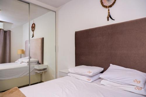 um quarto com 2 camas e um espelho em Casa aconchegante em Goiânia em Goiânia