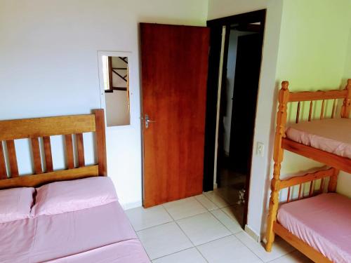 Habitación con 2 literas y puerta en Hostel Guaxinim en Caraguatatuba