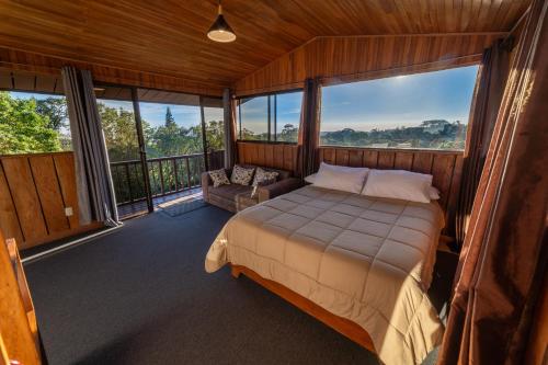 1 dormitorio con cama y sofá en el balcón en Campo Verde B&B - Monteverde Costa Rica en Monteverde Costa Rica