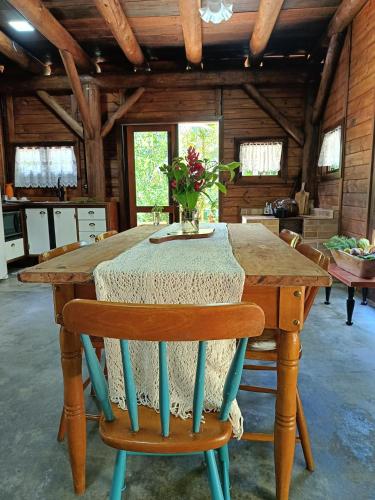 a wooden table with a vase of flowers on it at Chalé Graciosa in Rodeio