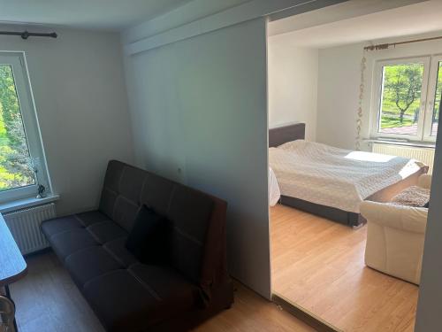 a living room with a couch and a bed at Dom wczasowy Rychertówka in Grzebieniec