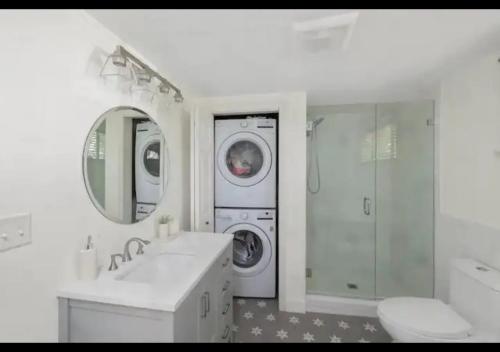 a white bathroom with a washing machine and a washer at Seaside Serenity, Your Pine Point Beach Paradise in Scarborough