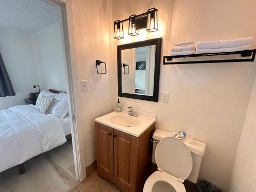 een badkamer met een toilet, een wastafel en een bed bij Alpine Lodge in Mount Shasta
