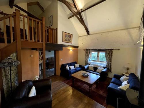 a living room with blue couches and a wooden floor at The Apple Press - Sweethay in Taunton