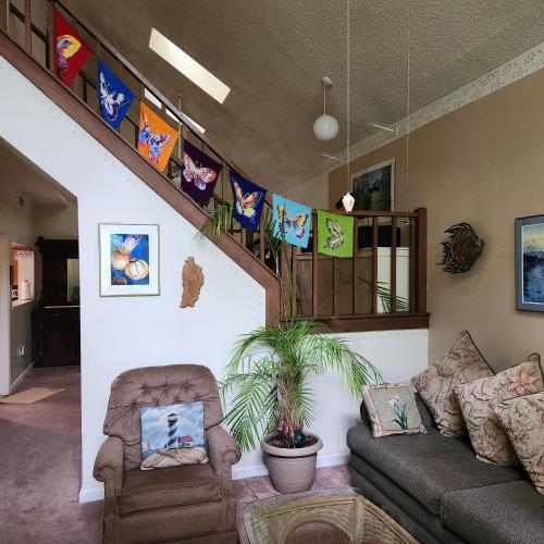 a living room with a couch and a staircase with flags at Massanutten Resort Home - Quiet, Convenient, Family- and Pet-Friendly in Massanutten