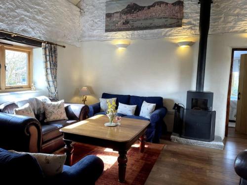 a living room with couches and a table and a fireplace at The Apple Press - Sweethay in Taunton
