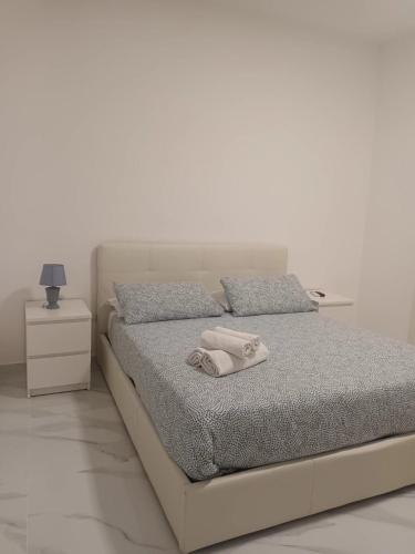 a white bedroom with a bed with a towel on it at Cuore di Napoli Centro in Naples