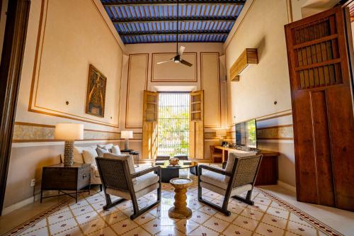 a living room with two chairs and a couch at Hacienda San Antonio Hool in Mérida