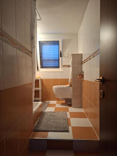 a bathroom with a toilet and a sink and a window at Apartments Romana in Slatine