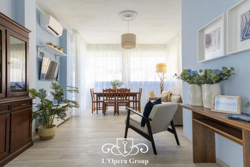 Una sala de estar con paredes azules y un comedor. en Scent of the Sea Apartment - L'Opera Group, en La Spezia