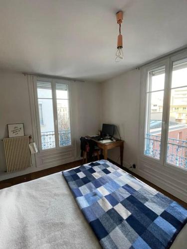 une chambre avec un lit, un bureau et des fenêtres dans l'établissement Parisian Nest - Comfort appartement, à Paris