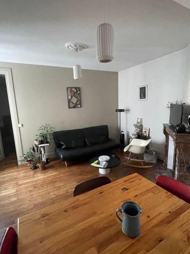 un salon avec une table en bois et un canapé dans l'établissement Parisian Nest - Comfort appartement, à Paris