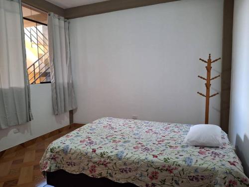 um quarto com uma cama com uma colcha e uma janela em Disfruta la Selva Peruana Pto.M em Puerto Maldonado
