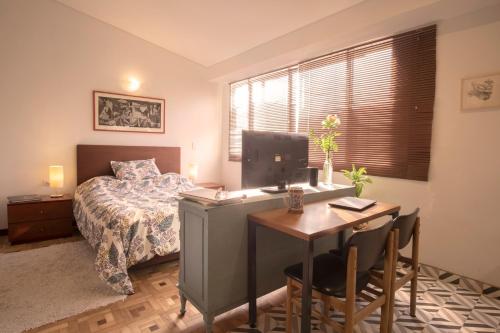 a bedroom with a bed and a desk with a computer at Casa estudios Normandia in Bogotá