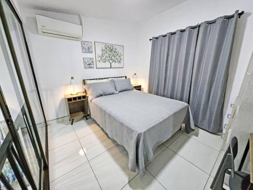 um pequeno quarto com uma cama e uma janela em Loft Moderno y Tranquilo # 7 na Cidade do Panamá