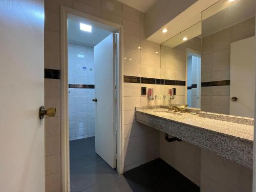 W łazience znajduje się umywalka i lustro. w obiekcie Plan Córdoba Centro w Córdobie