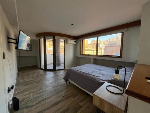 a bedroom with a bed and a large window at Plan Córdoba Centro in Cordoba