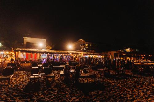 a group of chairs on a beach at night at Che Zipolite Hostel & Beach Club in Zipolite
