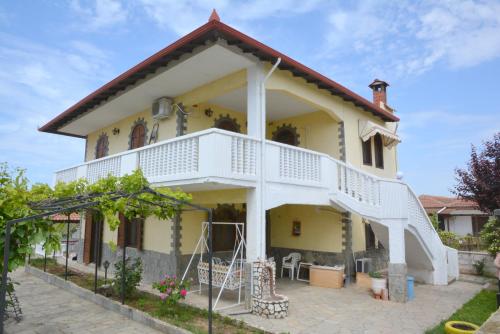 a large yellow house with a white balcony at Emmanuel's Summer House in Sozopoli