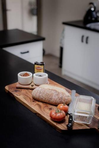 a cutting board with a loaf of bread and tomatoes at Twelve 30 - Easy Airport Access in Cambridge