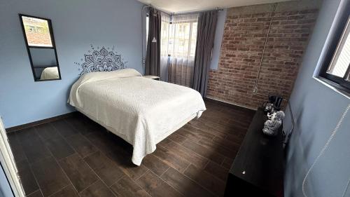 a bedroom with a bed and a brick wall at Cómodas y espaciosas Habitaciones para viajeros por trabajo o vacaciones in Tultitlán