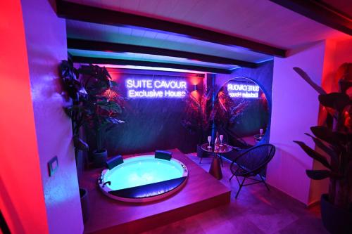 Suite Cavour Exclusive House Private Luxury SPA في برينديسي: غرفة مع حوض استحمام ساخن في غرفة مع أضواء وردية
