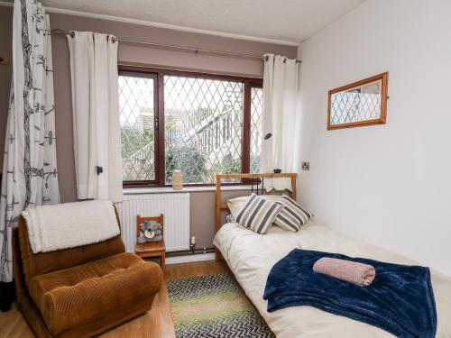 sypialnia z łóżkiem, krzesłem i oknem w obiekcie Llys-Yr-Onnen w mieście Carmarthen