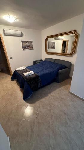 a bedroom with a blue bed and a mirror at B&B Mamma Mia s in Airola