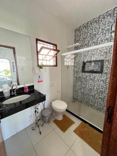 a bathroom with a toilet and a sink and a shower at Casa por do Sol amarelo in Araruama