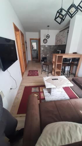 uma sala de estar com um sofá e uma mesa em Apartments Durmitor em Žabljak