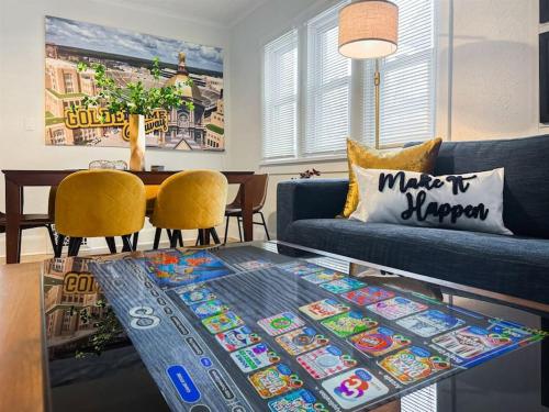 a living room with a blue couch and a glass table at Step into School Spirit at the Golden Dome Getaway in South Bend