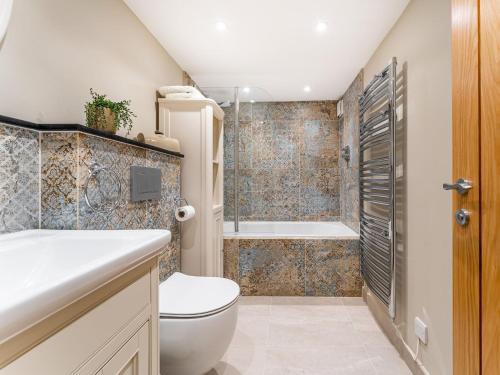een badkamer met toilet en ligbad bij Dell Cottage in Ambleside