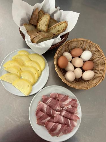 a table with plates of bread and eggs and baskets of meats at Agriturismo Ponte Due Archi in Raccuia